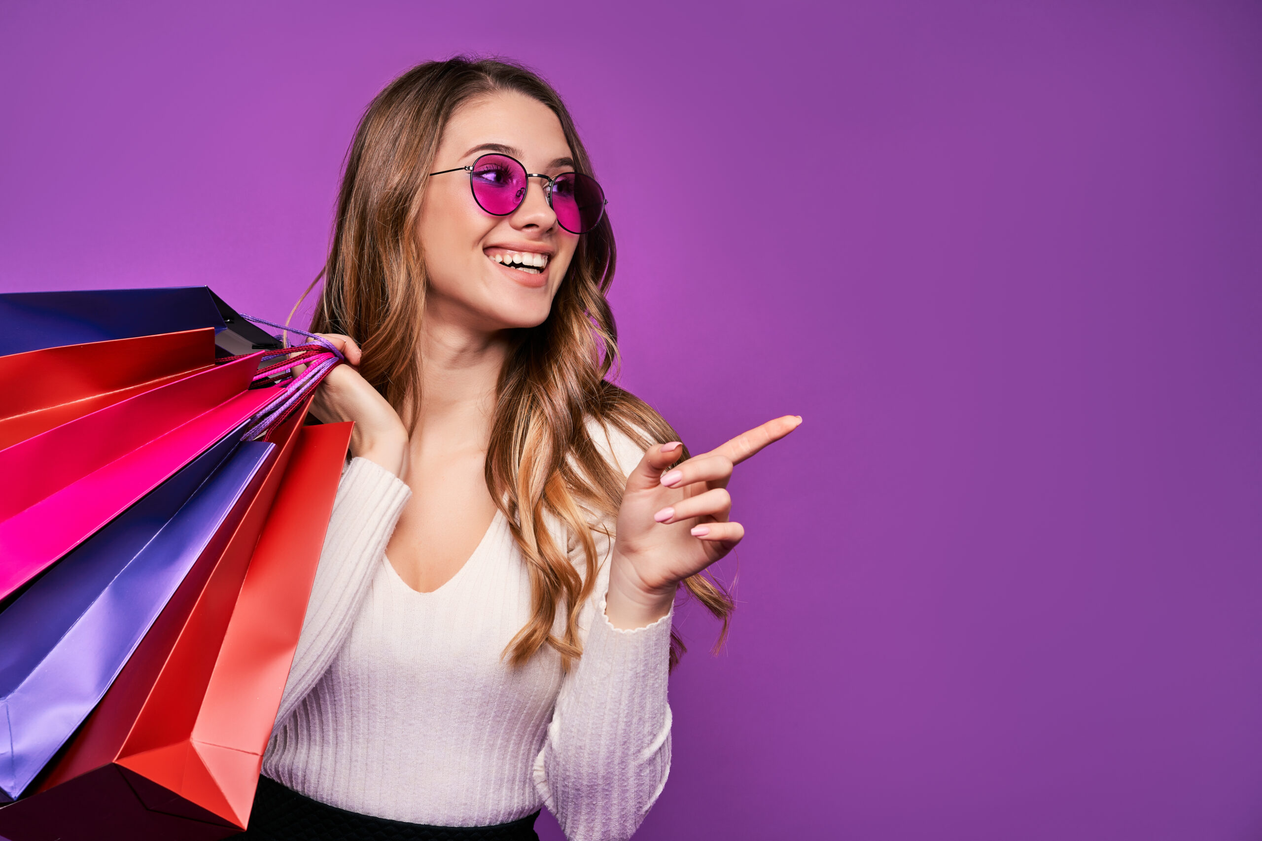 Beautiful Smiling Young Blonde Woman Pointing Sunglasses Holding Shopping Bags Credit Card Pink Wall Scaled